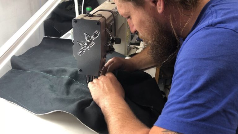 גבר תופר בד במכונת תפירה